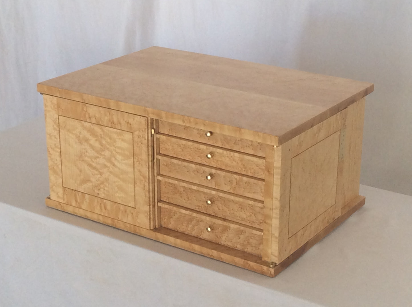 This photo shows how the door opens to lay flat against the cabinet's side. It gives access to five of the drawers. Please note the small brass lever on the inside edge of the left hand door. It is a spring operated lever that pins the door to the top of the cabinet, securing the left hand door. The right hand door has the key lock that latches to the left hand door.