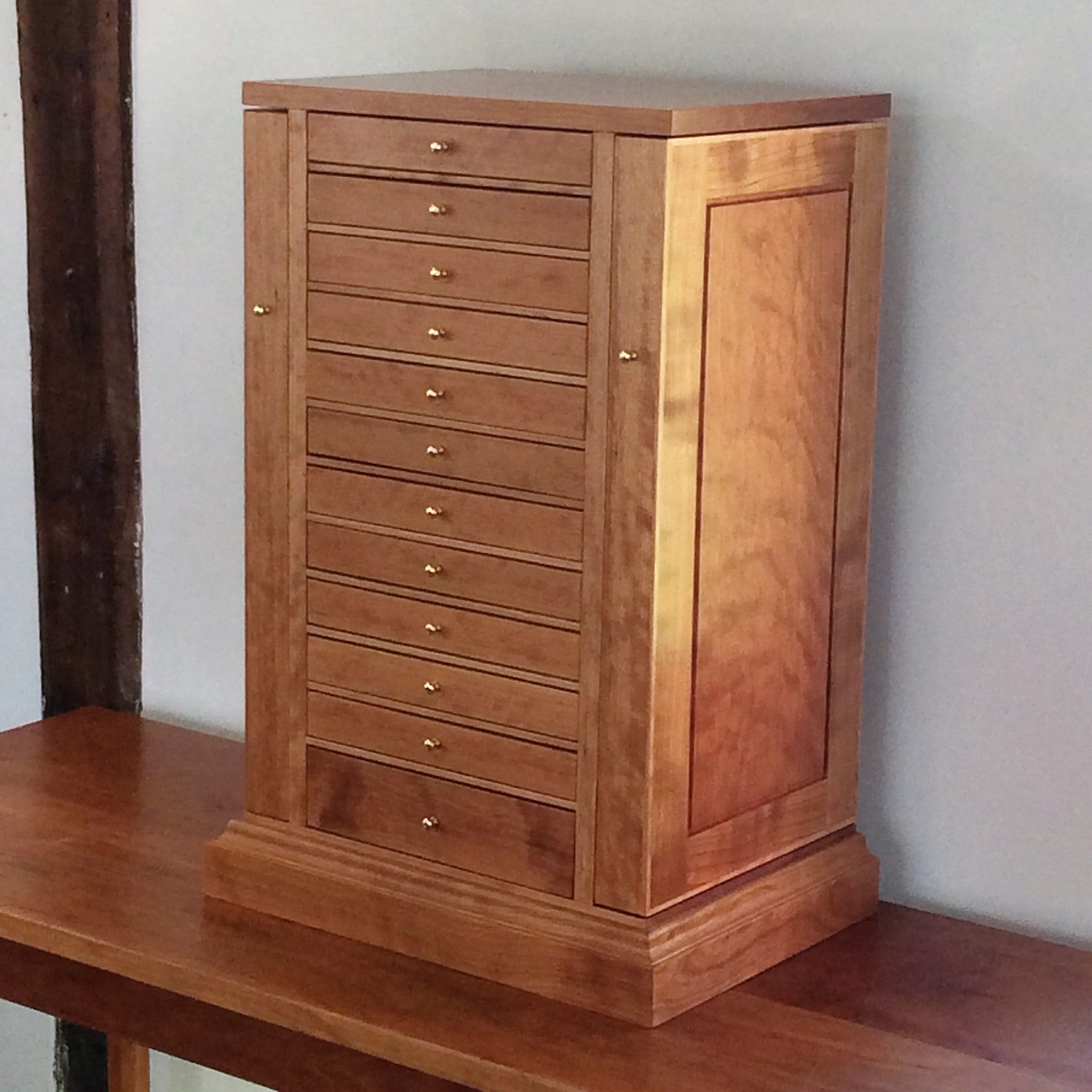 This tower was customized with a wrap around base and brass knobs. This one was made from curly cherry wood.